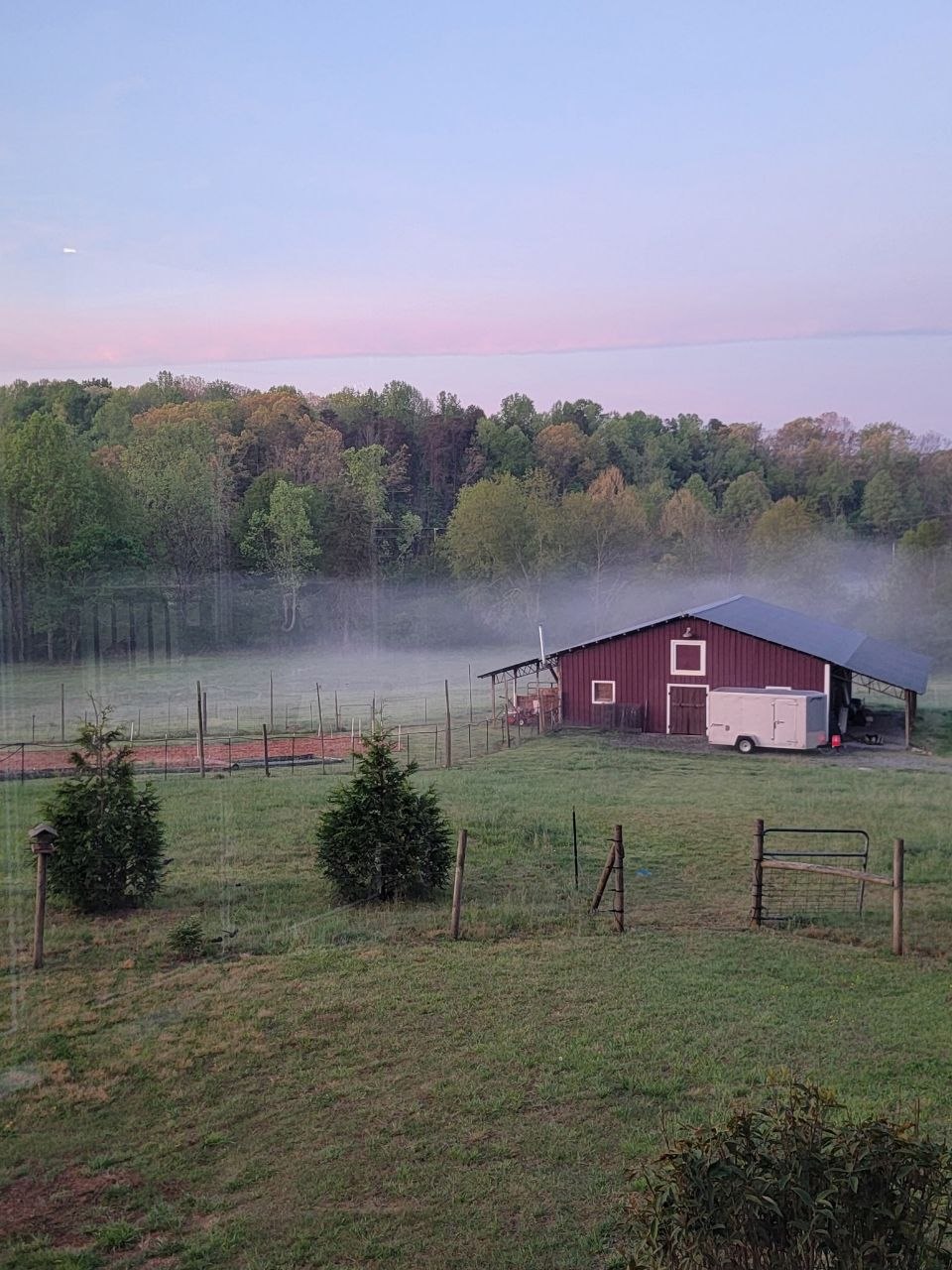 Weathered red barn at the edge of a field